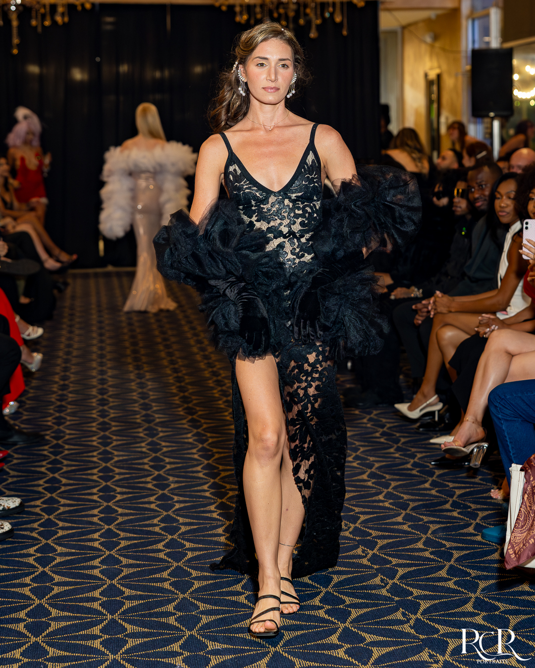 Model in a black lace dress walking the Gatsby Affair runway
