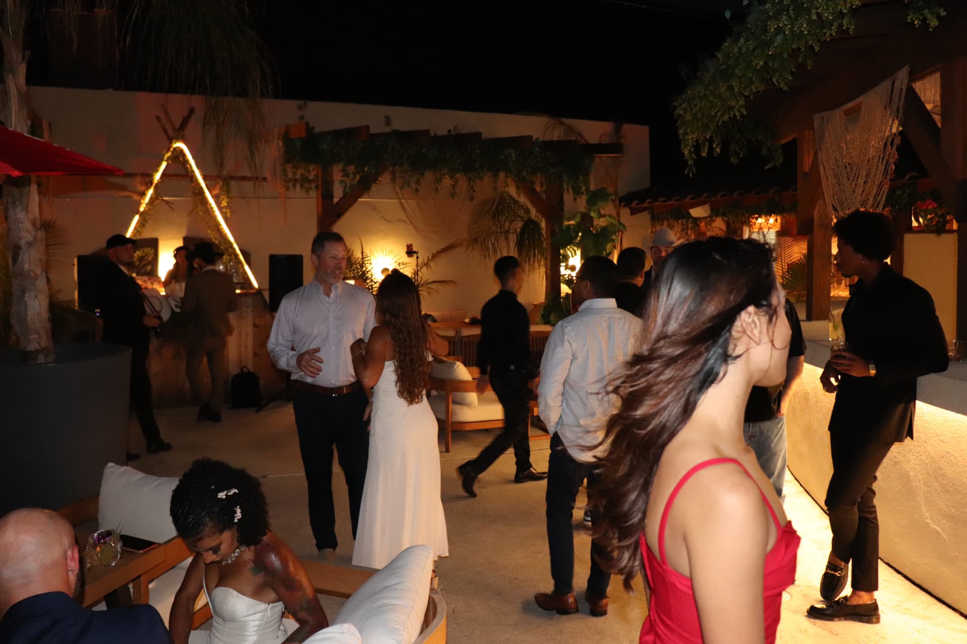 Guests gathering outdoors under string lights at the Old Money evening