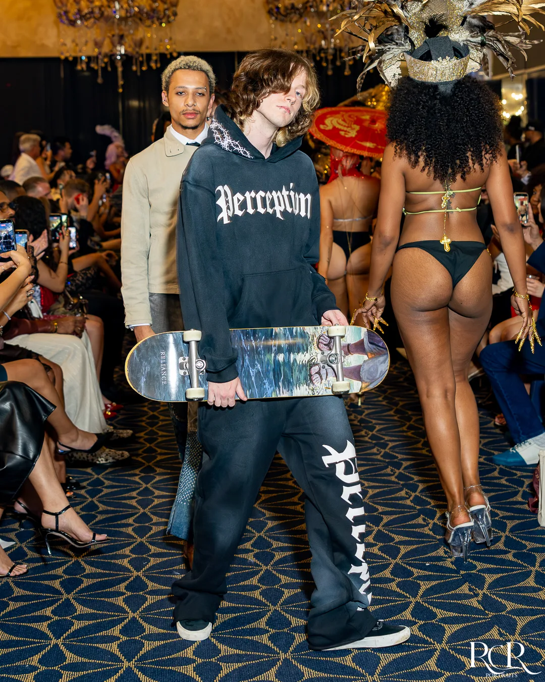 Runway model carrying a skateboard in a streetwear look at The Gatsby Affair