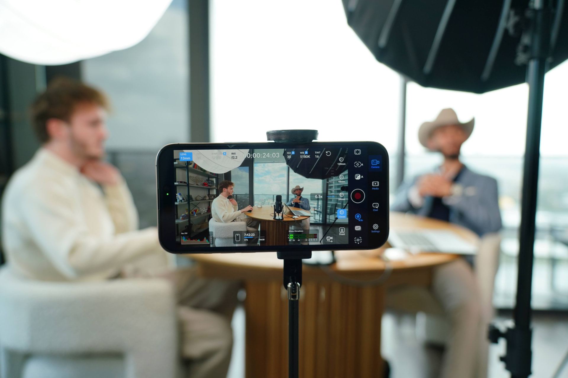 Phone-mounted camera showing a live view of the HLE podcast interview